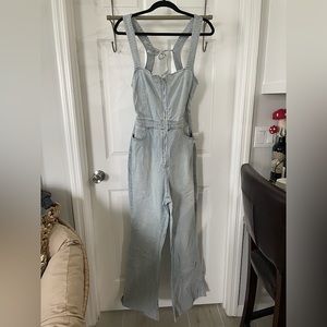 One piece denim jumpsuit. Open back with wide legs. Stretchier denim material.